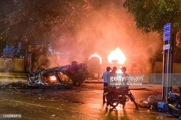 TOPSHOT - A vehicle belonging to the security personnel and a bus set alight is pictured near Sri Lanka's outgoing Prime Minister Mahinda Rajapaksa's official residence in Colombo May 9, 2022. - At least three people were killed and more than 150 wounded on May 9 in a wave of violence between government supporters and demonstrators demanding President Gotabaya Rajapaksa's resignation. (Photo by ISHARA S. KODIKARA / AFP) (Photo by ISHARA S. KODIKARA/AFP via Getty Images)