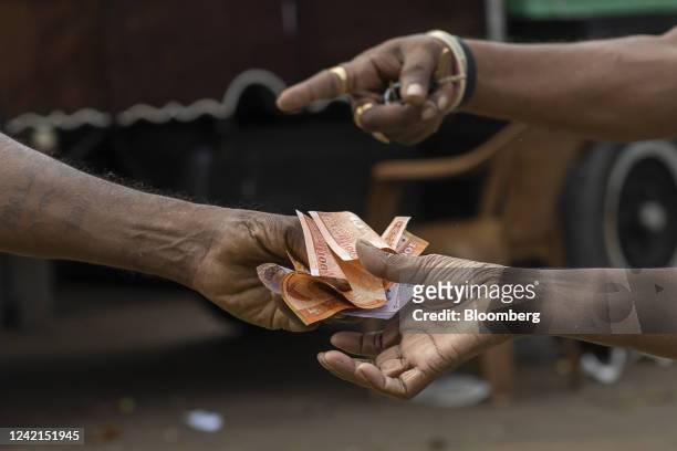 A customer receives Sri Lankan rupee banknotes at the open market in Colombo, Sri Lanka, on Wednesday, July 27, 2022. Sri Lanka is scheduled to announce its consumer prise index (CPI) figures on July 29. Photographer: Buddhika Weerasinghe/Bloomberg via Getty Images