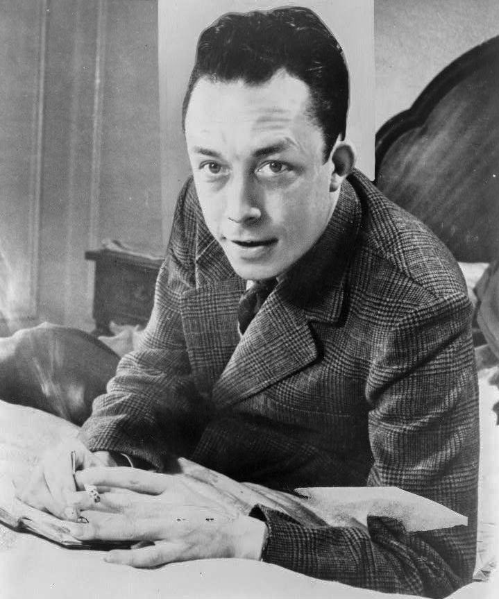 Albert Camus gagnant de prix Nobel portrait en buste posé au bureau faisant face à gauche cigarette de tabagisme