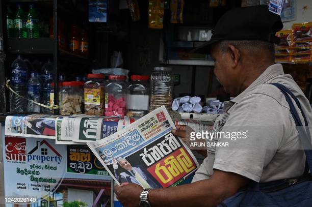 A man reads a newspaper with front page news of Sri Lanka's president-elect Ranil Wikeramasinghe at a newsstand in Colombo  on July 21, 2022. - Sri Lanka's six-time prime minister Ranil Wickremesinghe was set to be sworn in as president on July 21, with officials saying he would set up an all-party unity cabinet to confront the country's economic crisis. (Photo by Arun SANKAR / AFP) (Photo by ARUN SANKAR/AFP via Getty Images)