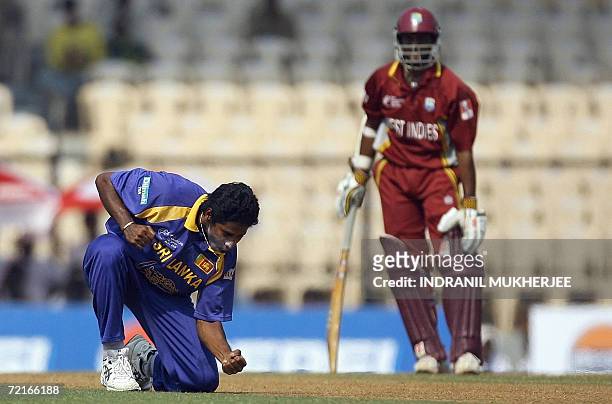 Mumbai, INDIA:  West Indian cricketer Shivnarine Chanderpaul (R) looks on as Sri Lankan bowler Chaminda Vaas celebrates after taking the wicket of unseeen West Indian cricketer Ramnaresh Sarwan during an ICC Champions Trophy 2006 match between Sri Lanka and West Indies at The Brabourne Stadium in Mumbai, 14 October 2006.     West Indies won the toss and after electing to bat have scored 43 runs for the loss of 3 wickets after 13 overs.  AFP PHOTO/Indranil MUKHERJEE  (Photo credit should read INDRANIL MUKHERJEE/AFP via Getty Images)