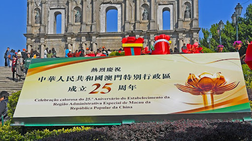 新华社照片,澳门,2024年12月17日 澳门大三巴牌坊前摆放着庆祝海报(12月17日摄)。 回归祖国25周年前夕,澳门街头装扮一新,洋溢着喜庆气氛。 新华社记者 陈铎 摄