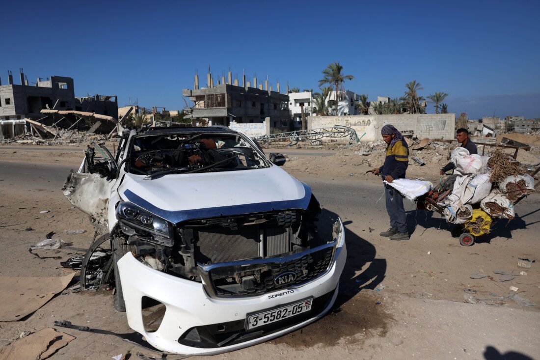 People check a car hit by an Israeli strike in Khan Yunis in the southern Gaza Strip on November 30, 2024, in which five people were reported killed, including three World Central Kitchen (WCK) workers, according to a report by the civil defence in the Palestinian territory. The Israeli army said in a statement that it had carried out a strike on "a vehicle transporting a terrorist who participated in the October 7 massacres", adding that "the assertion that the terrorist was travelling among workers of the WCK is under investigation.” (Photo by BASHAR TALEB / AFP)
