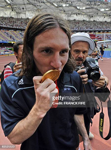 Argentinian forward Lionel Messi kisses his gold medal as he leaves the pitch after attending the men's Olympic football tournament medal ceremony at the national stadium in Beijing during the 2008 Beijing Olympic games on August 23, 2008. Argentina won gold ahead of Nigeria and Brazil.       AFP PHOTO / FRANCK FIFE (Photo credit should read FRANCK FIFE/AFP via Getty Images)