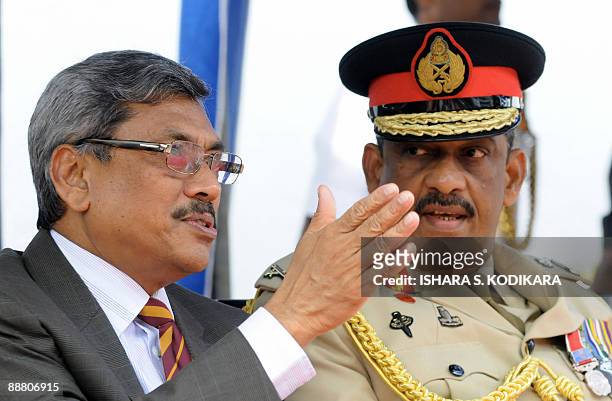 Sri Lankan defence secretary Gotabhaya Rajapakse (L) makes a point as army chief Sarath Fonseka looks on during a felicitation ceremony in Colombo on July 3, 2009.  President Rajapakse and the island's top defence chiefs were felicitated by a Colombo school after security forces crushed the Tamil Tiger rebels and killed chief Velupillain Prabhakaran in mid-May.  AFP PHOTO/Ishara S. KODIKARA (Photo credit should read Ishara S. KODIKARA/AFP via Getty Images)