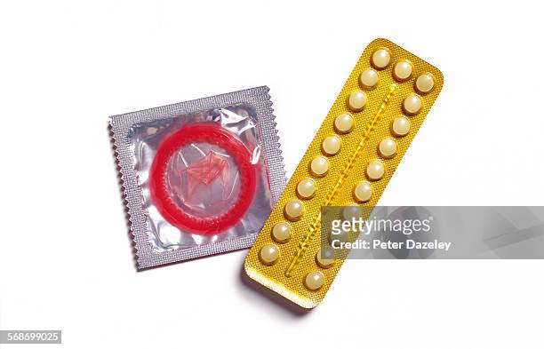 Birth control pill and condom on white background.