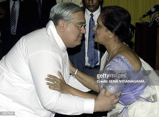 COLOMBO, SRI LANKA:  Sri Lankan President Chandrika Kumaratunga (R) hugs her brother Anura Bandaranaike (L) after swearing him in as the minister of Industry, Tourism and Investment Promotion in Colombo, 10 April 2004. Kumaratunga inducted a 31-member cabinet for the new minority government, but her main Marxist ally boycotted the official ceremony signalling fissures after their Freedom Alliance narrowly won elections.   AFP PHOTO/Sena VIDANAGAMA  (Photo credit should read SENA VIDANAGAMA/AFP via Getty Images)