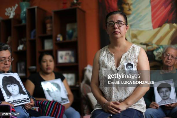 Gisella Ortiz, relative of one of the victims of the "La Cantuta" massacre -where nine university students and one professor were killed by the "Colima" death squad during the government of Fujimori- poses for a picture next to other relatives of victims of Fujimori's brutal rule, at her home in Los Olivos district, Lima, on December 26, 2017. Peru's ailing former leader Alberto Fujimori on Tuesday asked the public for forgiveness, two days after receiving a presidential pardon that sparked street protests. President Pedro Pablo Kuczynski ordered the pardon of Fujimori and seven other prisoners on humanitarian grounds, placing himself in the middle of a political crisis just days after he avoided impeachment. "We are here as relatives to reject this illegal pardon, because it does not correspond to the gravity of the crimes," Gisella Ortiz, from a group of victims' families, told reporters. / AFP PHOTO / LUKA GONZALES / TO GO WITH AFP STORY by Carlos MANDUJANO, Francisco JARA (Photo credit should read LUKA GONZALES/AFP via Getty Images)
