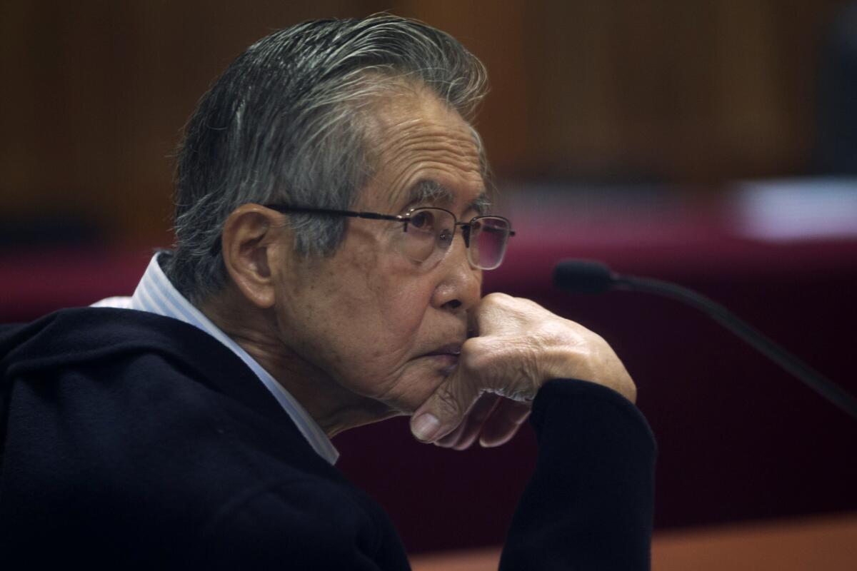 FILE - Peru's jailed, former President Alberto Fujimori, photographed through a glass window, attends his trial at a police base on the outskirts of Lima, Peru, June 28, 2016. His daughter Keiko Fujimori announced in a post on X that he died of cancer on Wednesday, September 11, 2024. (AP Photo/Martin Mejia, File)