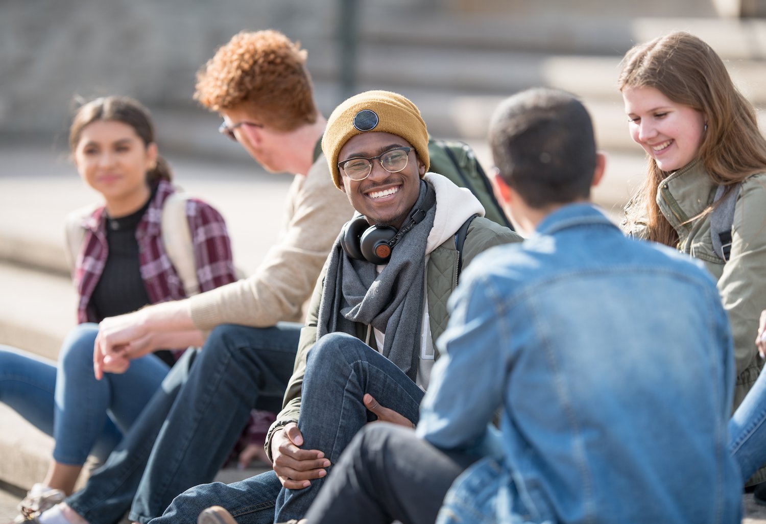 4e2165e91928beed8972ffd14ae39995 man in yellow beanie sitting on steps with friends