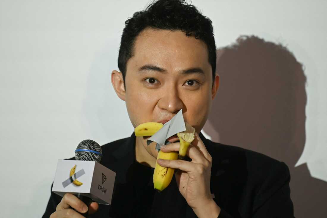 Chinese-born crypto founder Justin Sun eats a banana artwork composed of a fresh banana stuck to a wall with duct tape, in Hong Kong on November 29, 2024, after buying the provocative work of conceptual art by Italian artist Maurizio Cattelan at a New York auction for $6.2 million. The debut of the edible creation entitled "Comedian" at the Art Basel show in Miami Beach in 2019 sparked controversy and raised questions about whether it should be considered art -- Cattelan's stated aim. (Photo by Peter PARKS / AFP)