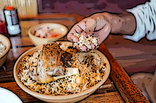 Man eating using hand a traditional biryani rice and chicken dish in local restaurant, Oman