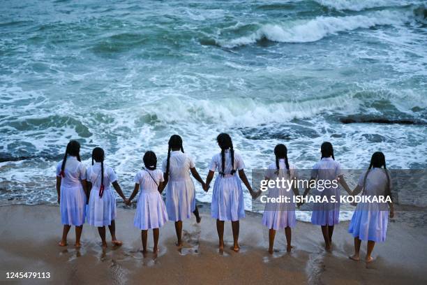 School girls hold hands while looking out at the Indian Ocean at Galle Face beach in Colombo on December 9, 2022. (Photo by Ishara S. KODIKARA / AFP) (Photo by ISHARA S. KODIKARA/AFP via Getty Images)