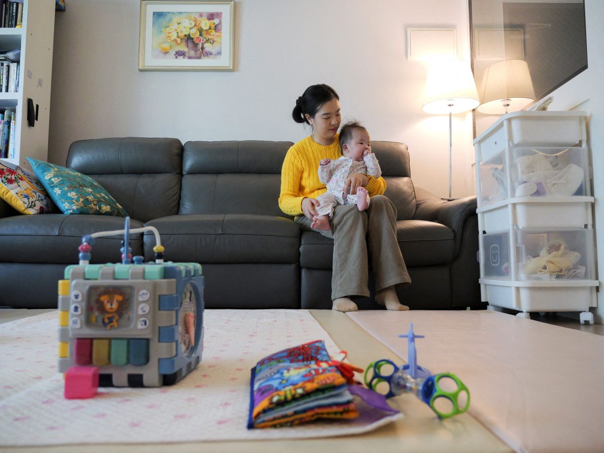 FILE PHOTO: Nam Hyun-jin takes care of her baby at her home in Seoul, South Korea, February 17, 2025. REUTERS/Daewoung Kim/File Photo