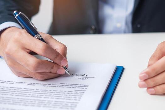 man signing on contract documents after reading man holding pen and approve on business report contract agreement law and deal concepts free photo