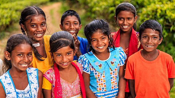 Sri Lankan young children posing on a tea plantaion. Their parents work on this tea plantattion near Nuwara Eliya, Ceylon. Sri Lanka (Ceylon) is the world's fourth largest producer of tea and the industry is one of the country's main sources of foreign exchange and a significant source of income for laborers.