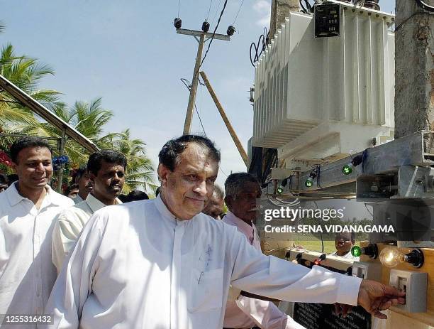 TOPSHOT - Sri Lanka's energy minister Karu Jayasuriya switches on the electricity supply in the village of Thondaimanaru in the embattled northern Jaffna peninsula 02 March 2003 as part of efforts to rebuild the area after decades of fighting. The government and Tamil Tiger rebels have asked for increased international support for reconstruction and rebuilding of damaged infrastructure before a final peace settlement is reached. AFP PHOTO Sena VIDANAGAMA (Photo by SENA VIDANAGAMA / AFP) (Photo by SENA VIDANAGAMA/AFP via Getty Images)