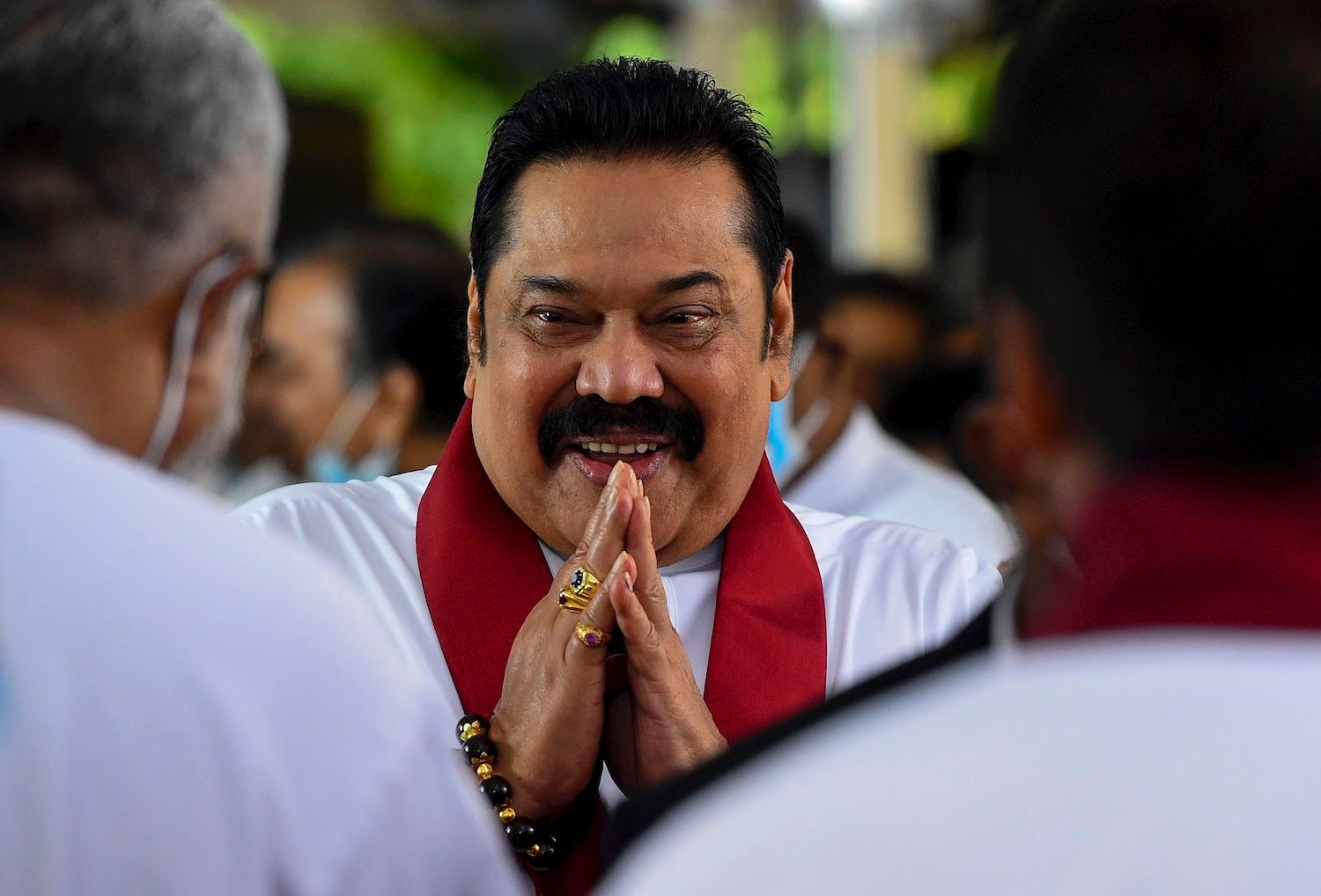 Sri Lanka's Prime Minister Mahinda Rajapaksa (C) greets as he arrives at his swearing-in ceremony at the sacred Kelaniya Raja Maha Buddhist temple, outside the capital Colombo on August 9, 2020. - Sri Lanka's ruling Rajapaksa brothers won an unprecedented two-thirds majority at the August 5 parliamentary elections that allowed them to rewrite the constitution and increase their power. (Photo by Ishara S. KODIKARA / AFP) (Photo by ISHARA S. KODIKARA/AFP via Getty Images)