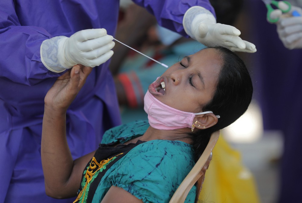 A Sri Lankan woman reacts as a medical officer attempts to collect a swab sample to test for Covid-19 in Colombo, Sri Lanka, Thursday, Oct. 22, 2020. (AP Photo/Eranga Jayawardena)