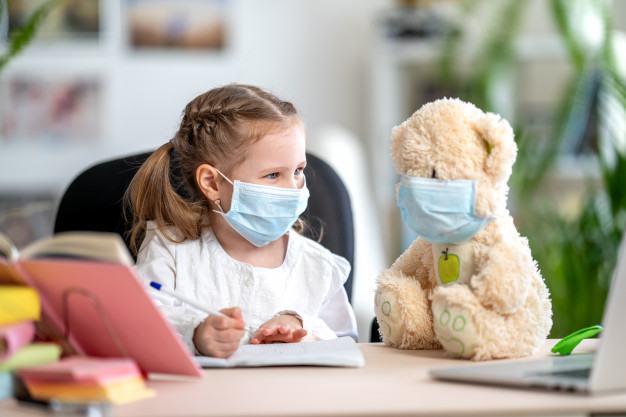 little girl mask with teddy bear doing homework coronavirus prevention 127093 1211