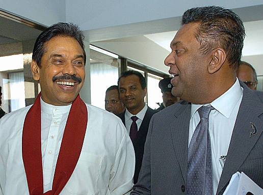 Colombo, SRI LANKA:  Sri Lankan President Mahinda Rajapakse, (L) who is also the Finance Minister, speaks with Foreign Minister Mangala Samaraweera after presenting the 2006 budget in parliament in Colombo, 08 December 2005. The president raised taxes and offered subsidies to lower income groups. AFP PHOTO/Lakruwan WANNIARACHCHI  (Photo credit should read LAKRUWAN WANNIARACHCHI/AFP via Getty Images)