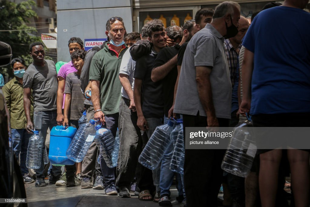 11 June 2021, Lebanon, Beirut: People with plastic gallons wait in line at a petrol station in Beirut. Lebanon is struggling with major shortages of medical supplies and fuel, leaving motorists queuing for hours at gas stations across the country, amid a deepening economic crisis. Photo: Marwan Naamani/dpa (Photo by Marwan Naamani/picture alliance via Getty Images)