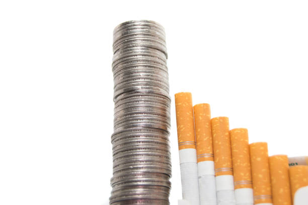 Rising expenses concept of cigarettes and coins isolated on white