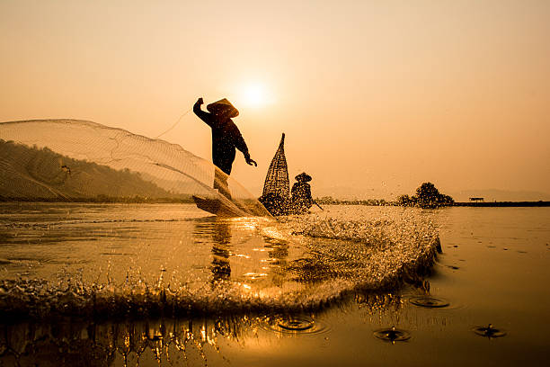Asia Fishermen on boat fishing at lake