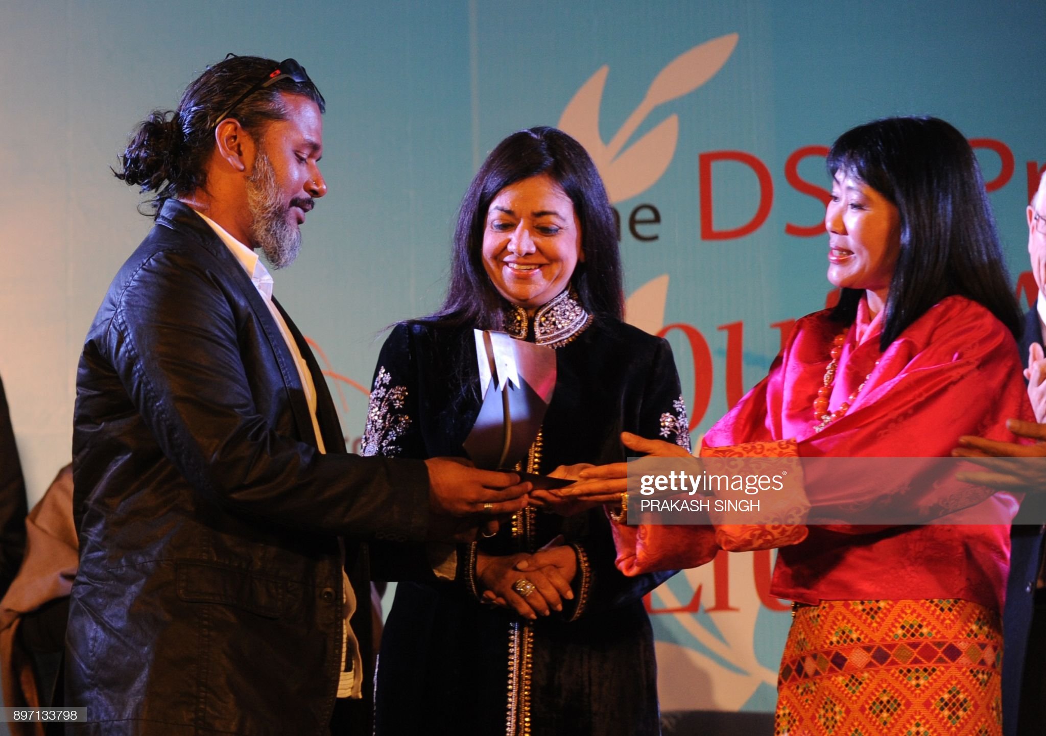 Queen Mother of Bhutan Ashi Sangay Choden Wangchuck (R) presents the DSC Prize for South Asian Literature 2012 to Sri Lankan debut Novelist Shehan Karunatilaka (L) for his book 'Chinaman' during the DSC Jaipur Literature Festival (JLF) in Jaipur on January 21, 2012. Sri Lankan debut Novelist Shehan Karunatilaka won the US$50,000  DSC Prize for South Asian Literature 2012 his book 'Chinaman', a novel that explores cricket as a metaphor to uncover a lost life and a lost history . AFP PHOTO / Prakash SINGH / AFP PHOTO / PRAKASH SINGH        (Photo credit should read PRAKASH SINGH/AFP via Getty Images)