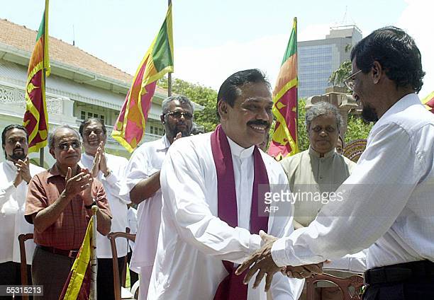 COLOMBO, SRI LANKA:  Sri Lankan Prime Minister Mahinda Rajapakse (C) shakes hands with the Secretary of the Marxist JVP,(People's Liberation Front) Tilvin Silva after exchanging a signed copy of an agreement in Colombo, 08 September 2005.   Rajapakse signed a deal with the island's main Marxist party under which he agreed to drop plans to share power with Tiger rebels, but said he hoped the move will not lead to a resumption of war.  AFP PHOTO/Lakruwan WANNIARACHCHI  (Photo credit should read LAKRUWAN WANNIARACHCHI/AFP via Getty Images)