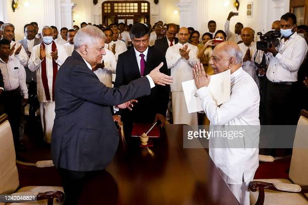Sri Lakan President Ranil Wickremesinghe (L) gestures after swearing in Dinesh Gunawardena (R) as Sri Lanka's new Prime Minister, at the prime minister office in Colombo on July 22, 2022. (Photo by AFP) (Photo by -/AFP via Getty Images)