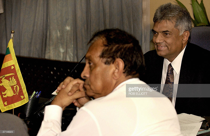 COLOMBO, SRI LANKA:  Sri Lankan Prime Minister Ranil Wickremesinghe (R) smiles as he talks with deputy leader of the ruling United National Party, Karu Jayasuriya (C) and other cabinet members (not in picture) during a meeting in Colombo, 10 November 2003.  Prime Minister Ranil Wickremesinghe told his cabinet that he was ready to face a snap election four years ahead of schedule to end a bitter stand-off with hostile President Chandrika Kumaratunga.   AFP PHOTO/Rob ELLIOTT  (Photo credit should read ROB ELLIOTT/AFP via Getty Images)
